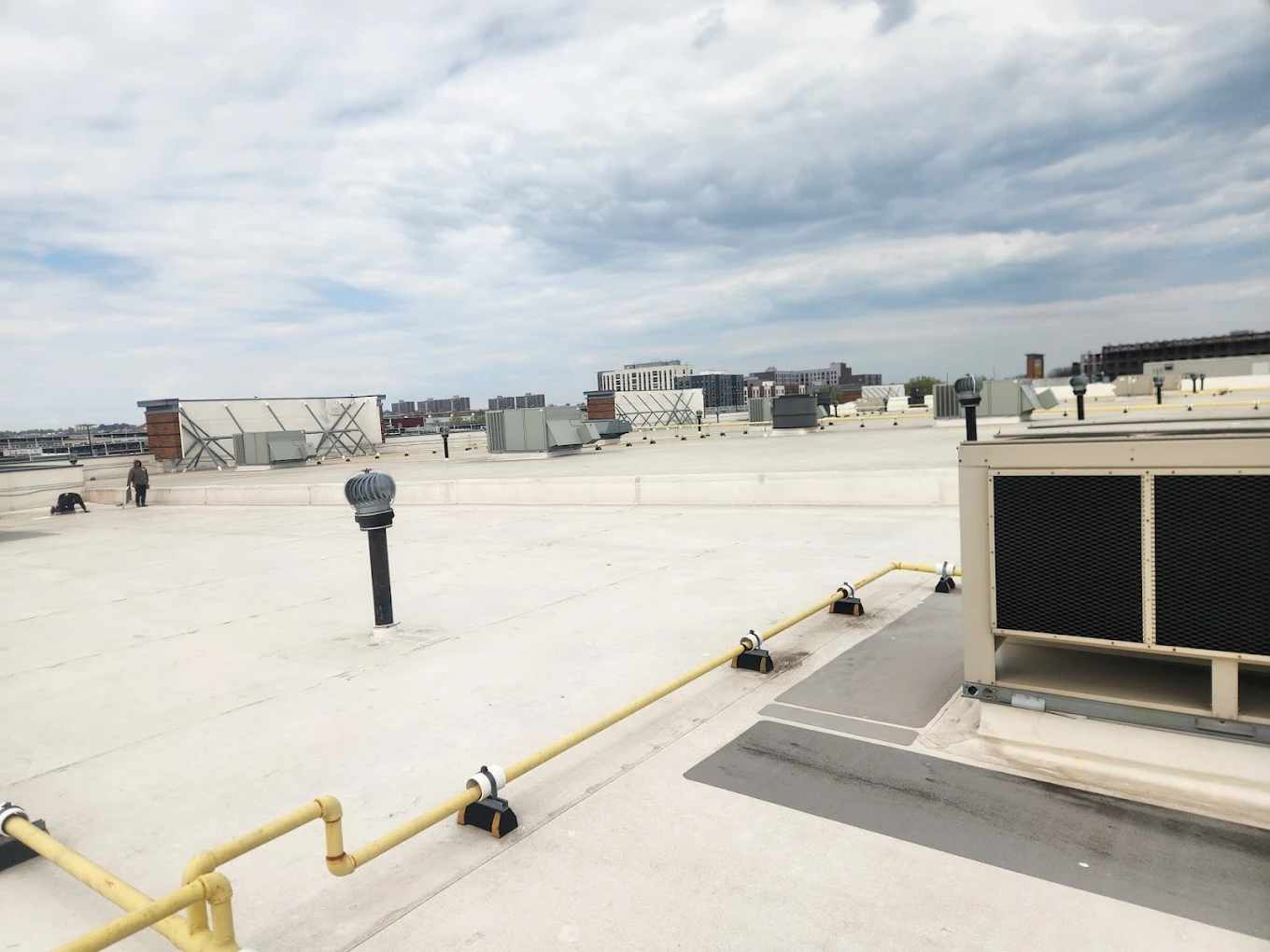 Flat roof installation on a commercial building in Bay Shore, NY — All-Star Roofing Inc. crew laying EPDM membrane on a retail plaza